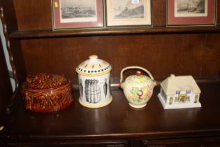 Three various pottery biscuit barrels and a brown