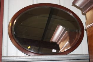 An Edwardian oval bevel edged wall mirror in mahog