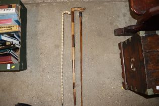 Three walking sticks to include a yellow metal col