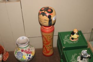 An Oriental Kokeshi wooden doll with hand painted