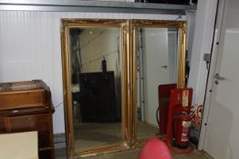A pair of large gilt framed bevel edged wall mirro