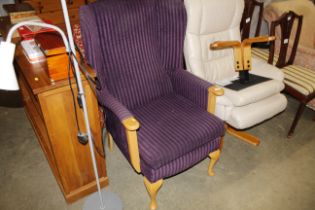 A wooden framed wing back armchair