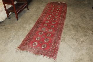 An approx. 9'11" x 3' Bokhara patterned rug