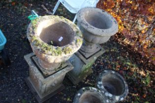 A pair of concrete planters raised on concrete pli