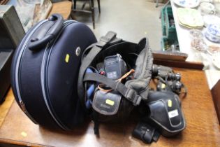 A pair of binoculars, a Minolta camera, a camcorde