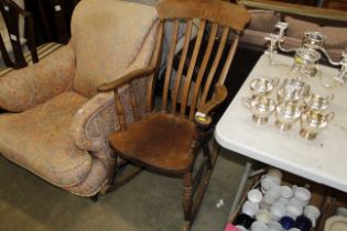 An antique elm slat back rocking chair