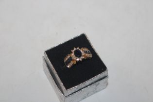 A dress ring set with blue and white coloured ston