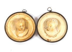 A pair of circular profile plaques of infants AF;