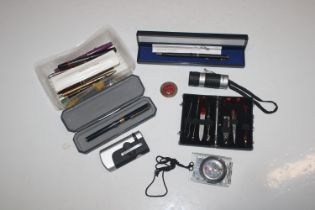 A box containing fountain pens, other pens, a Prot