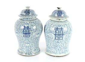 A near pair of antique Chinese blue and white baluster vases and covers of large size, one with four