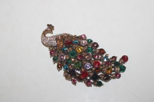 A brooch in the form of a peacock set with multi c