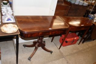 A Georgian mahogany fold over tea table raised on