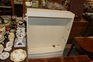 A white painted open fronted bookcase
