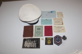 A medal for Brave Deeds, cloth badges, a soldiers service book; other ephemera and a naval cap