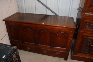 An 18th Century oak mule chest with hinged lifting top above four panels, central cupboards and