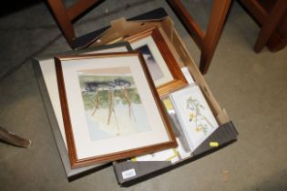 A box of various watercolours and prints