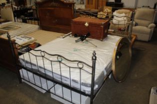 A wrought metal framed double bed and mattress