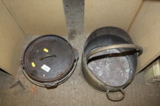 A brass coal bucket and a cast iron cooking pot wi