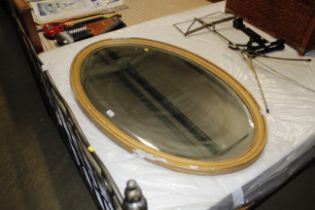 A large gilt framed oval bevel edged wall mirror A