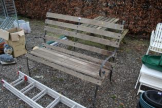 A wooden and metal framed garden bench with scroll
