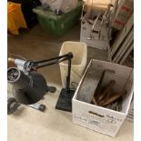 Black metal angle poise lamp with weighted base and assorted gardening tools including hand trowels,