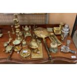 Twenty assorted brass items including candlesticks, nut cracker, bells,