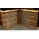 Two light oak three shelf bookcases, each with two glass sliding doors - each 89cm x 89cm x 22.