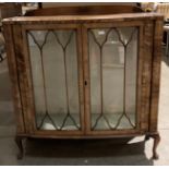 A walnut two door display cabinet, 102cm x 130cm high - damage to veneer.