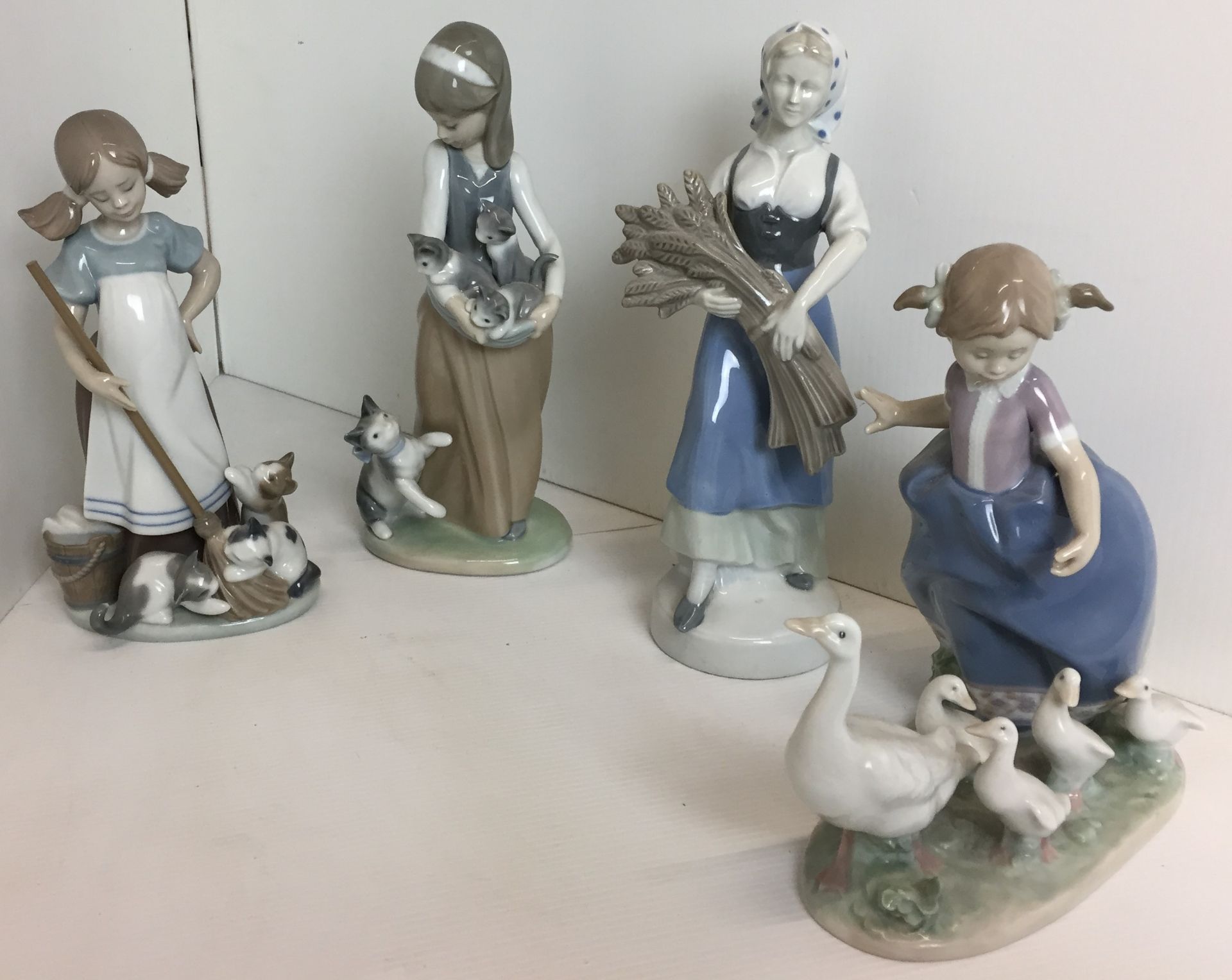 Four Lladro figures - two girls with kittens 24 and 21cm high,