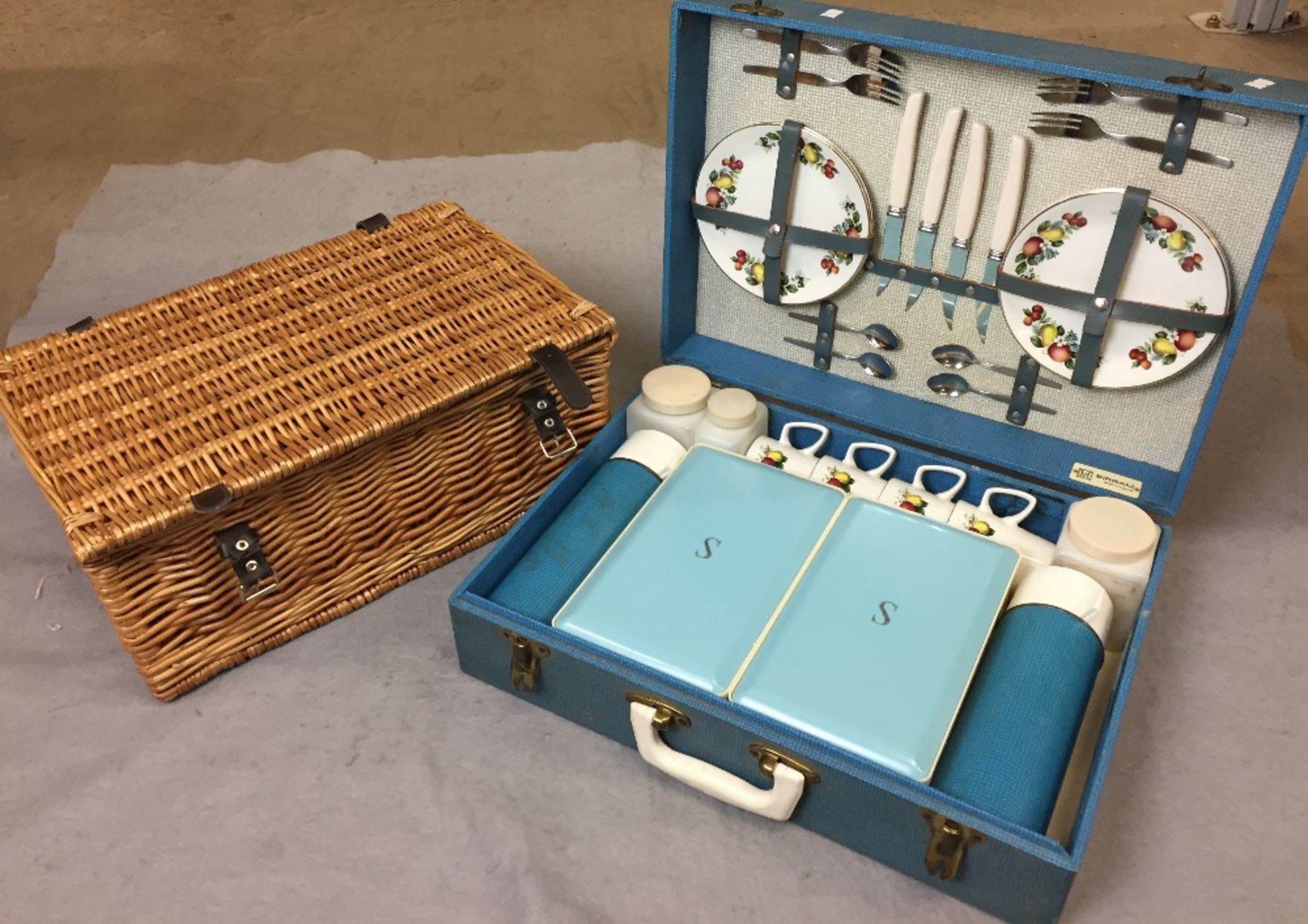 Two items - a Hawker Marris Sirram picnic set in blue case and empty wicker picnic basket