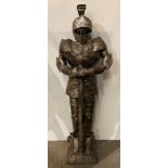 Thin metal statue of a knights armour holding sword,
