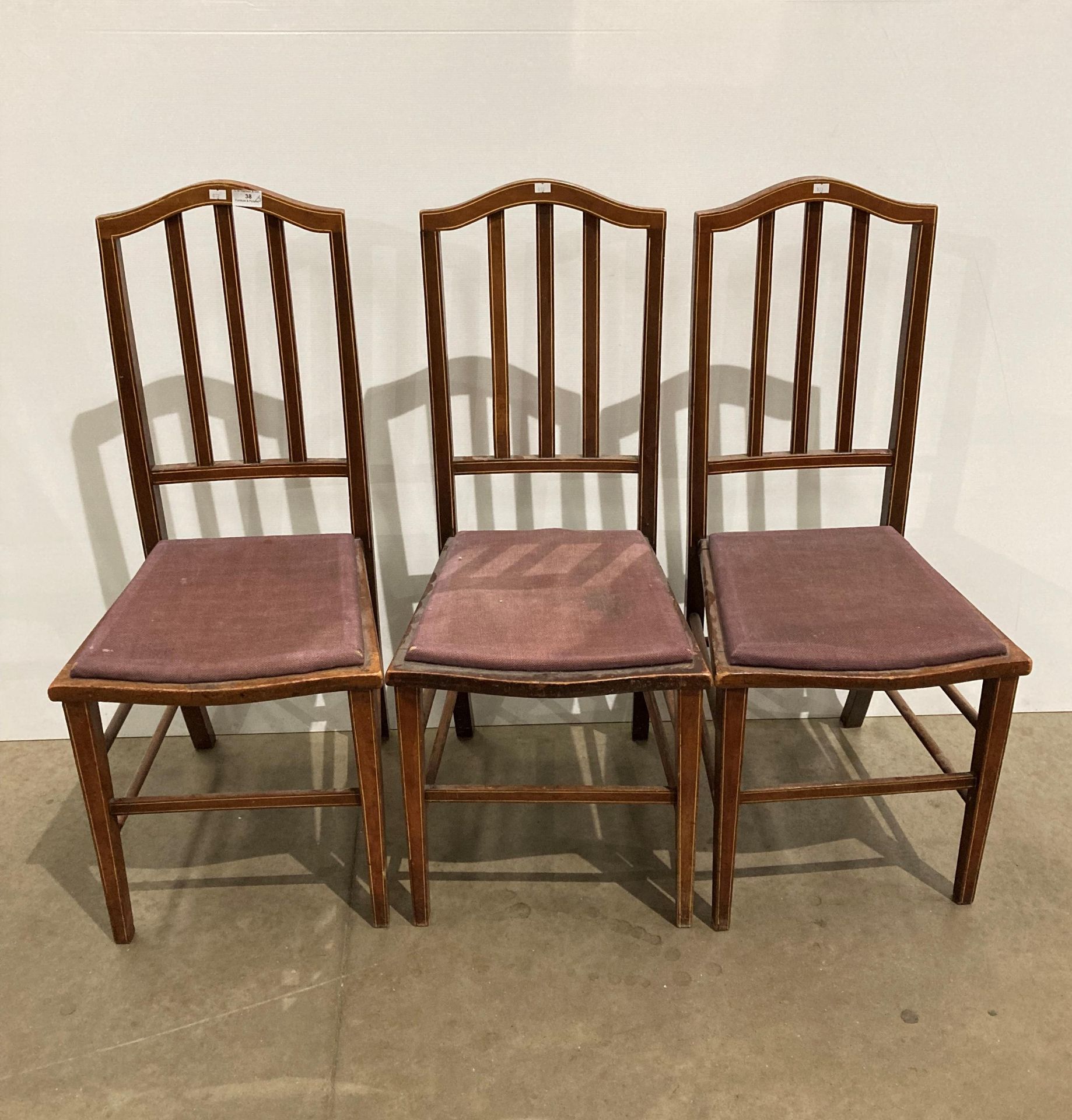 Three mahogany ladder back dining chairs with purple padded seats (saleroom location: kit area)