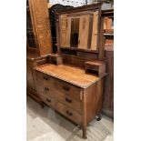 An oak dressing table with swing mirror and two trinket drawers over two short and two long drawers,