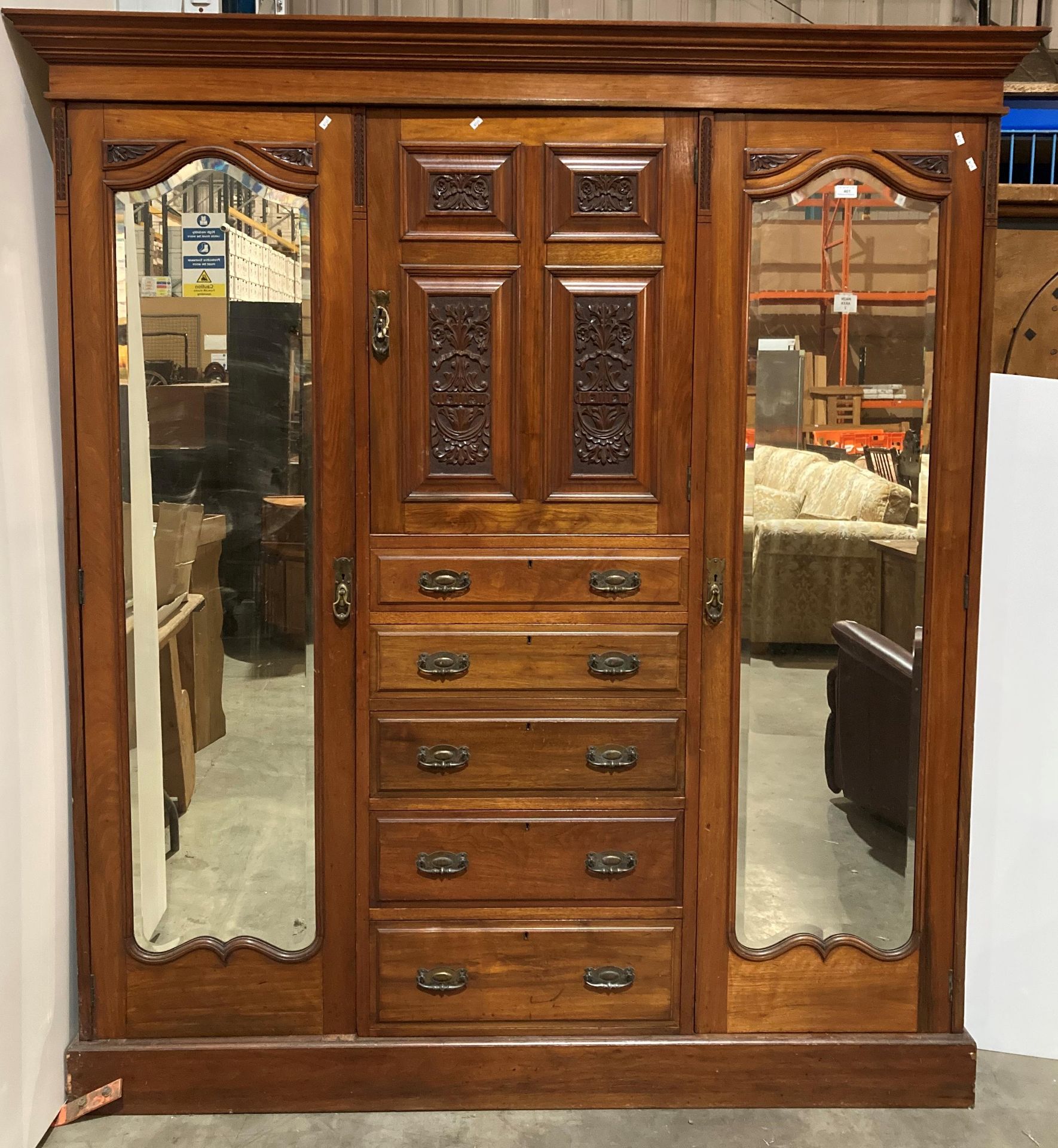 A carved walnut three section wardrobe with moulded cornice over single centred door with four