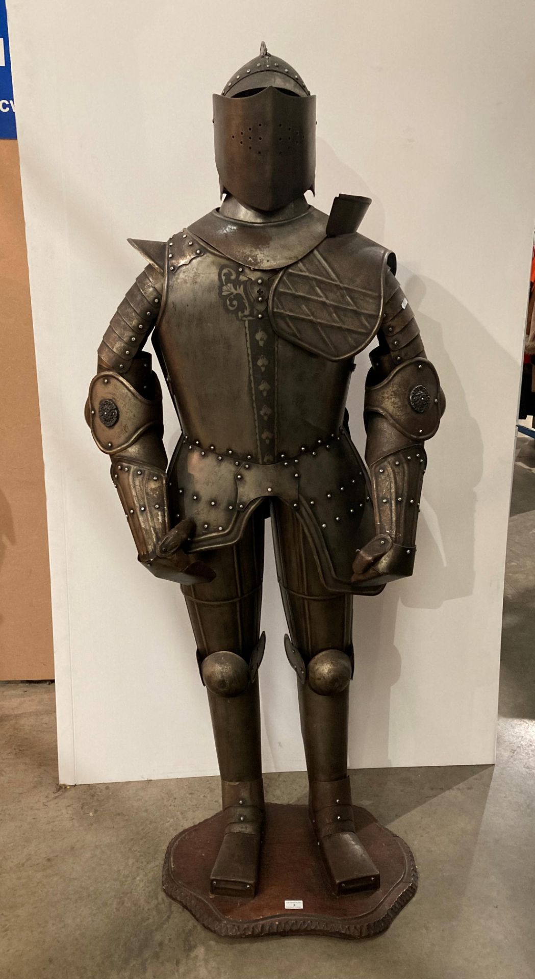 Metal reproduction full suit of armour on a mahogany frame with base,