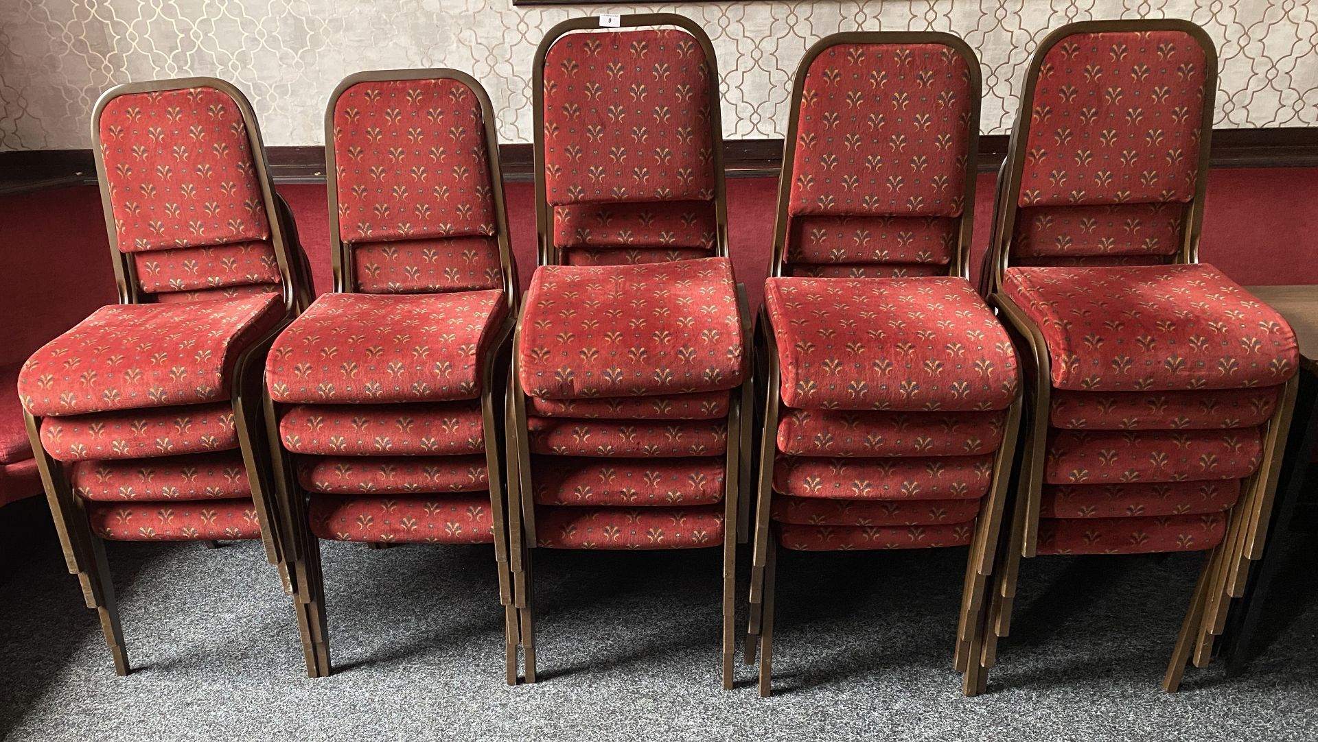 23 x red velvet upholstered metal framed stacking chairs.