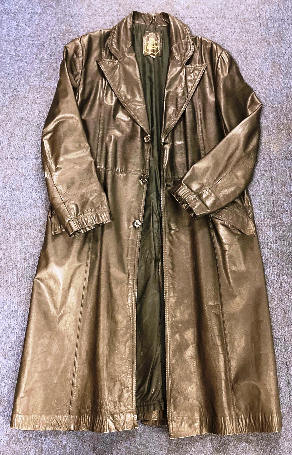 A fine leather, 'tailored by craftsmen' leather trench coat with button fastenings,