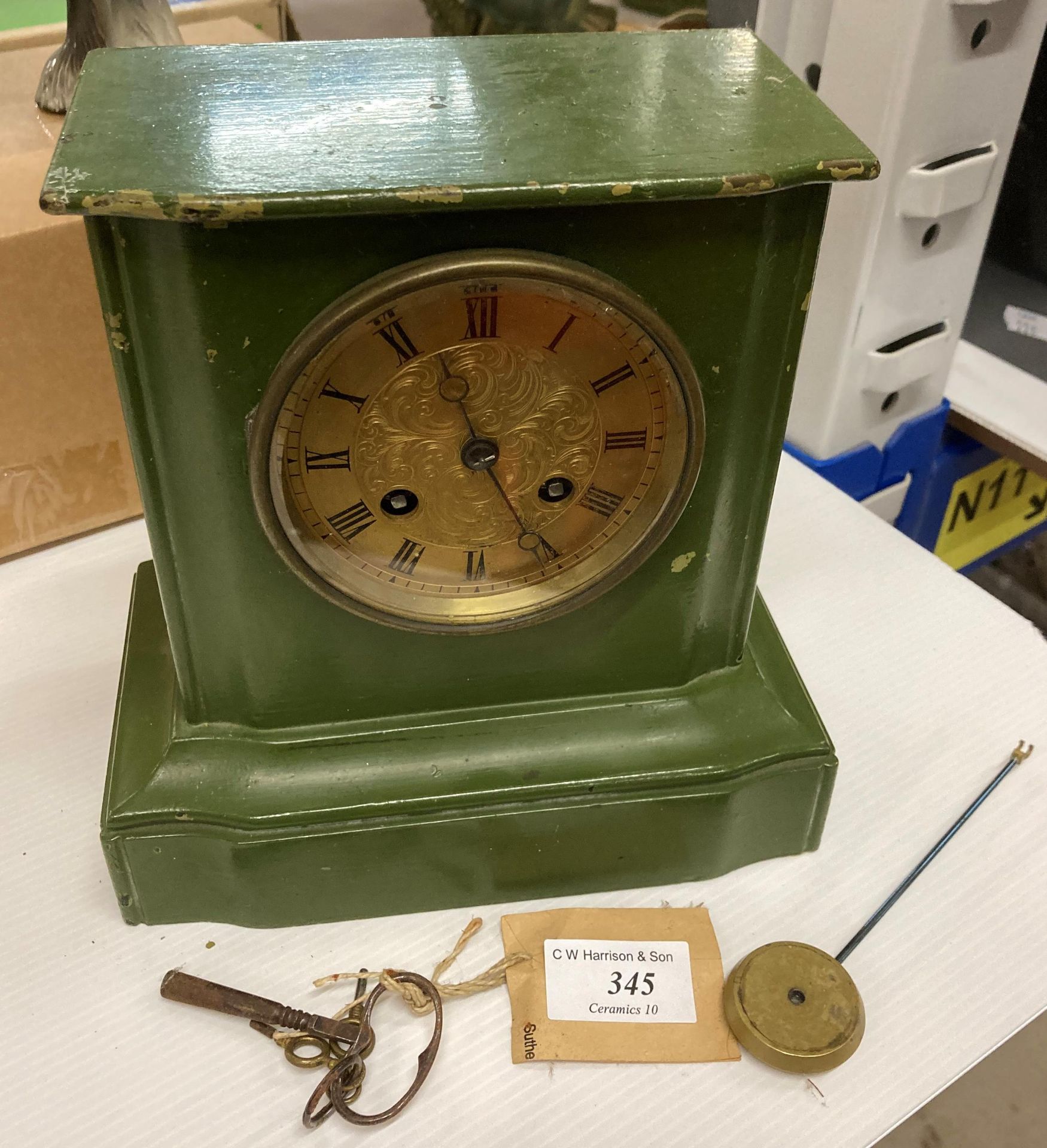 A green painted metal mantel clock with gold-coloured dial,