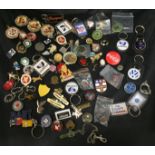 Tin containing sixty badges, keyrings,