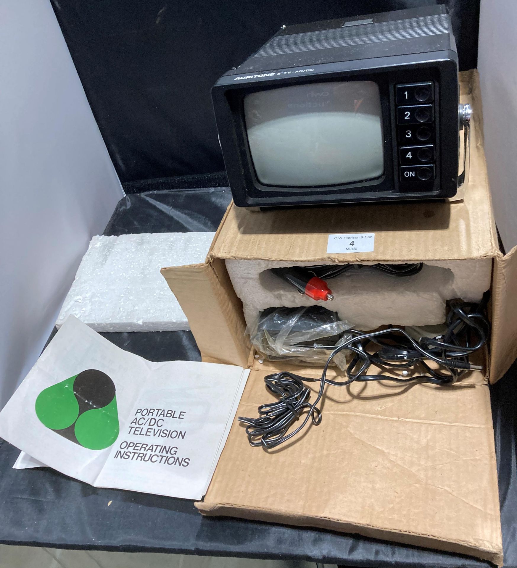 An Auritone 5" AC/DC portable television with cables and manual (no test)