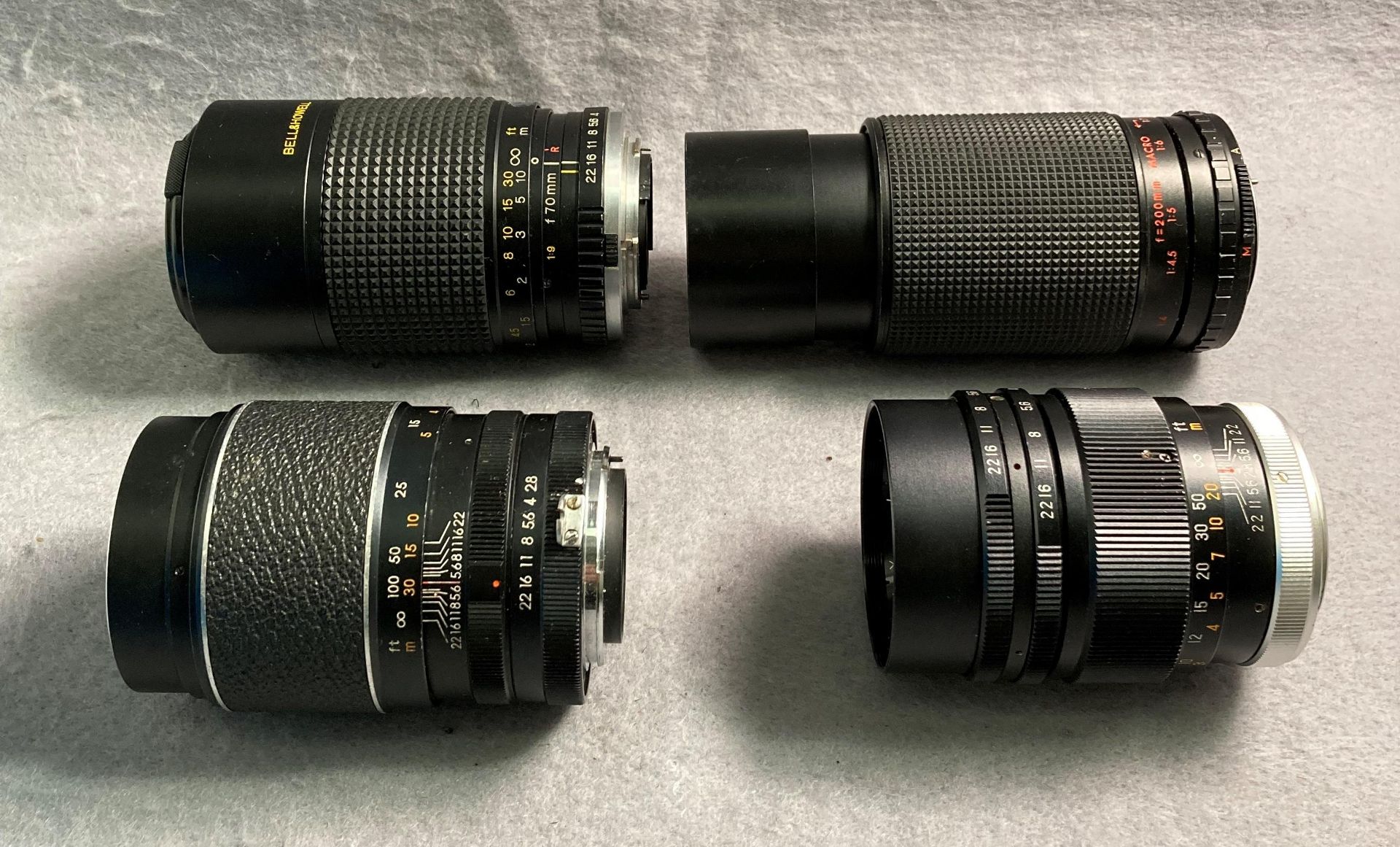 Four assorted camera lenses - Welmy 1:28 f=135mm, Bell Howell 1:4.