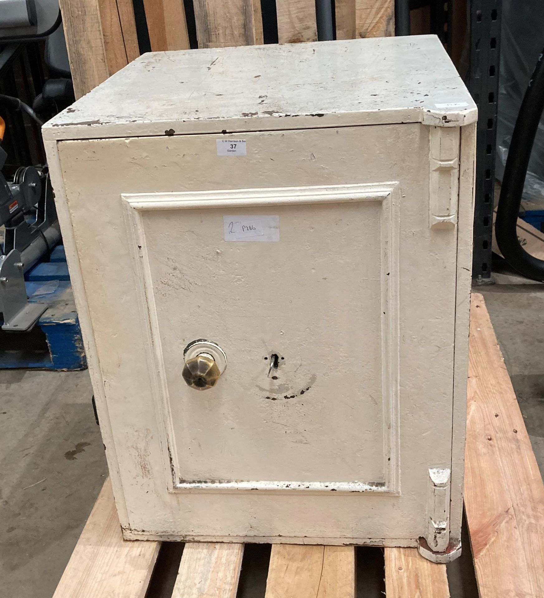 A white metal office safe with two internal drawers and one key,
