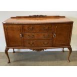 A burr walnut bow front three drawer, two door sideboard, on cabriole legs,