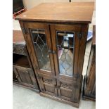 An Old Charm oak entertainment cabinet with two leaded glazed upper doors over two lower doors,