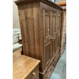 A three-piece pine bedroom suite comprised of three door wardrobe with four under drawers,