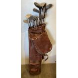 Vintage brown leather golf bag with hood and fifteen assorted golf clubs including two Mashie