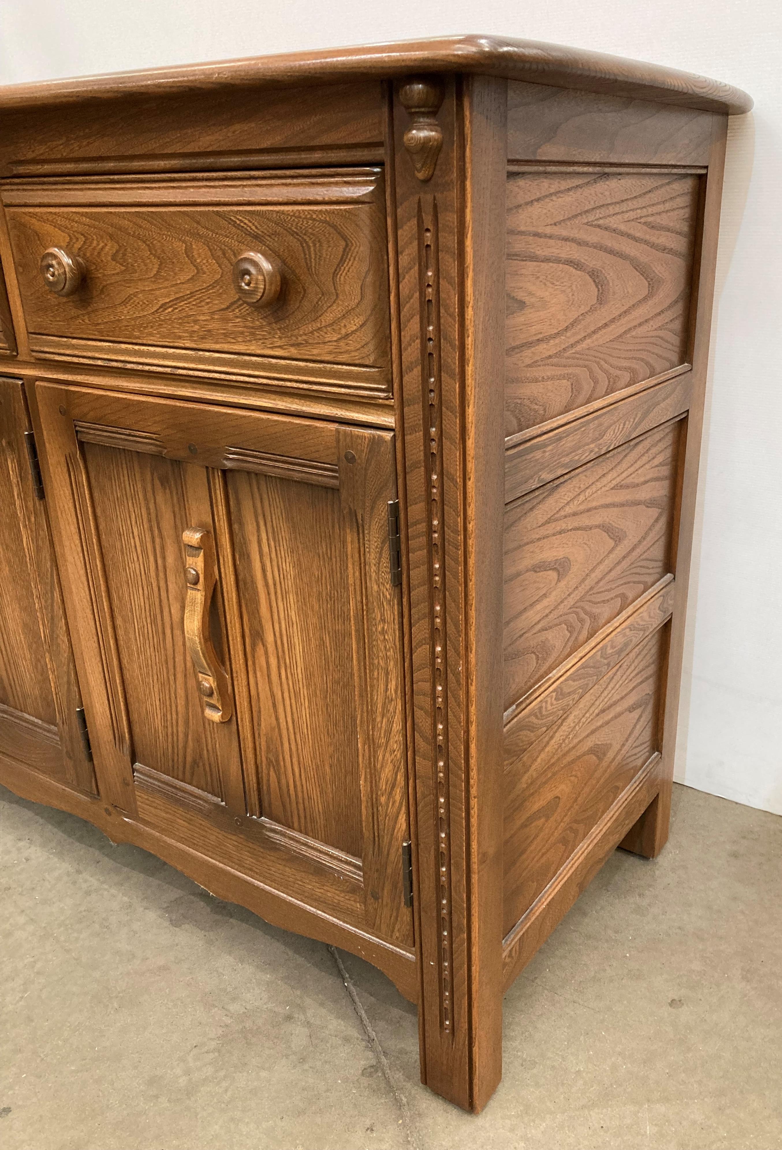 Ercol Lavenham dresser base, model 962D, with three drawers and three doors, in elm Golden Dawn, - Image 5 of 6