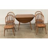 An Ercol drop leaf circular dining table and four Windsor dining chairs, no.
