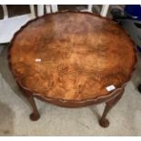 A walnut circular coffee table with pie-crust edging,