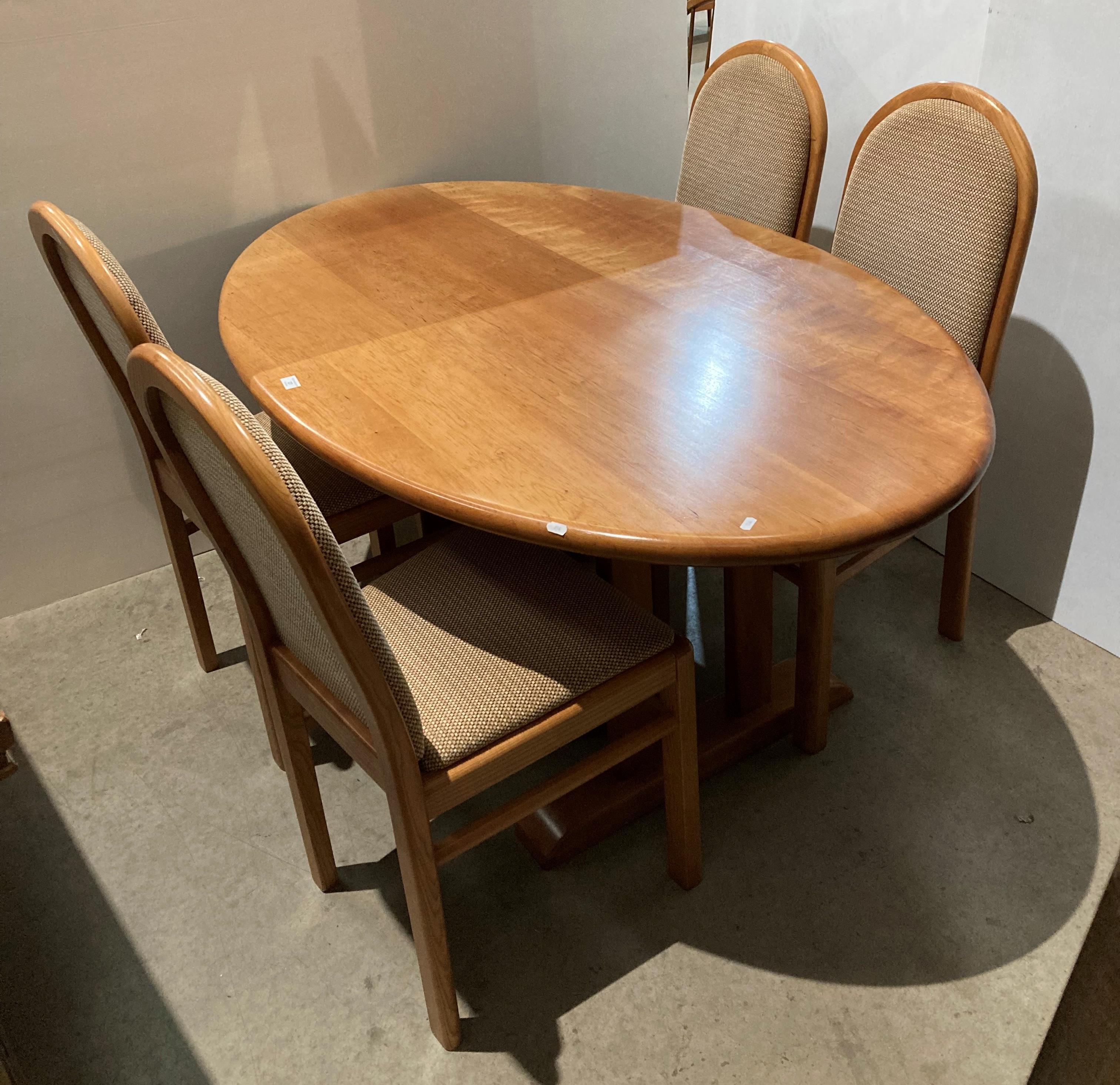 Light oak oval dining table and four chairs with light brown patterned fabric,